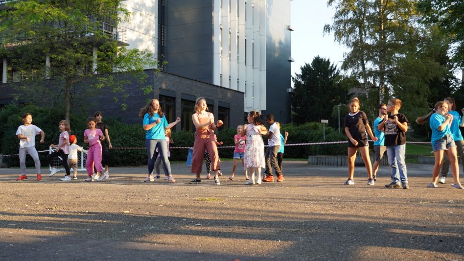 Eine Kinder- und Jugendgruppe studiert einen Flashmob ein.